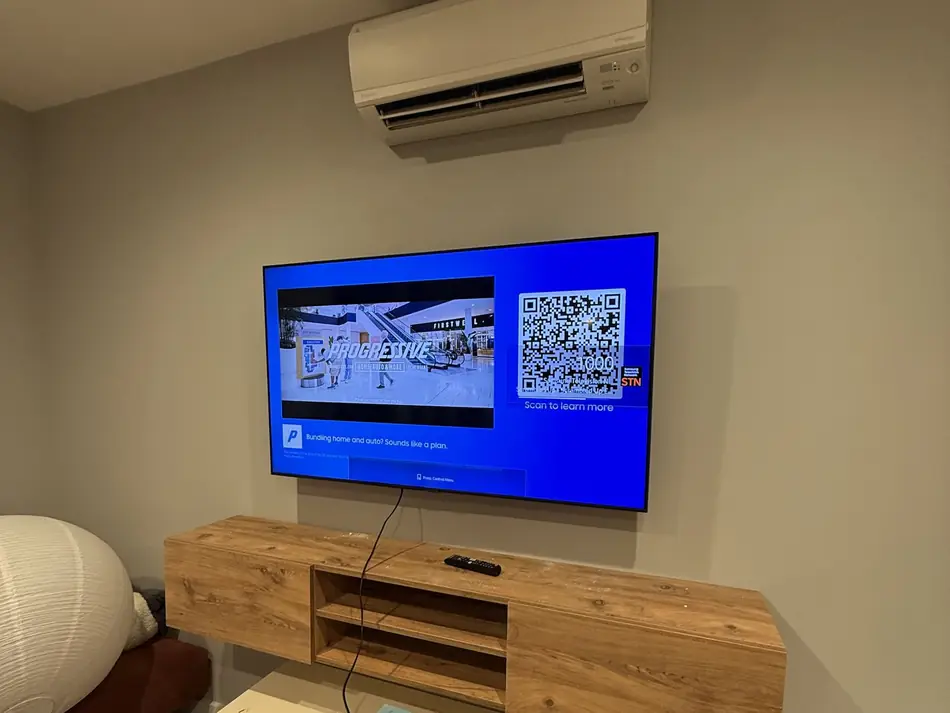 TV wall mounted above a floating wood console in a NYC apartment