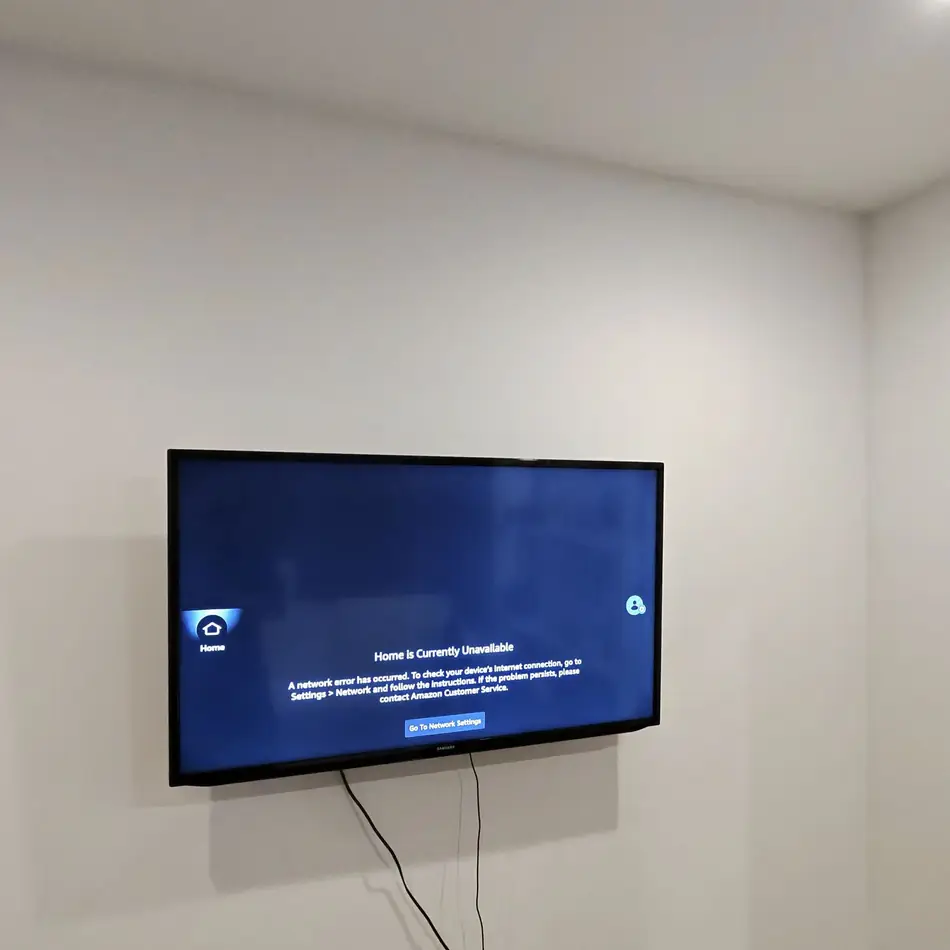 65 inch TV mounted and centred above a dresser in a NYC apartment